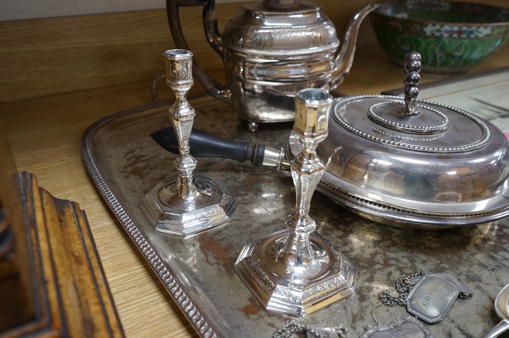 A pair of white metal candlesticks, a silver plated teapot circular tureen and cover spoons and forks and four spirit labels and large tray. Tray 73cm wide